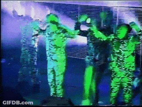 Group Of People Standing On Stage With Hands In Air GIF
