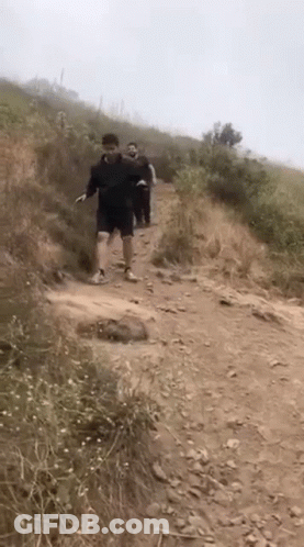 Group Of People Walking Up Dirt Path GIF