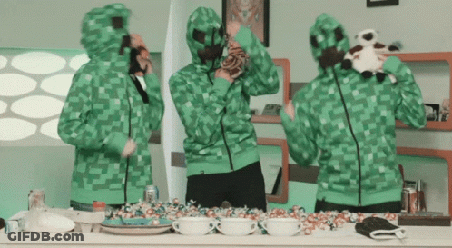 Group Of People Wearing Green Hoodies Standing Around Counter GIF