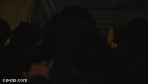 Group Of People With Spotlight In Dark Room GIF