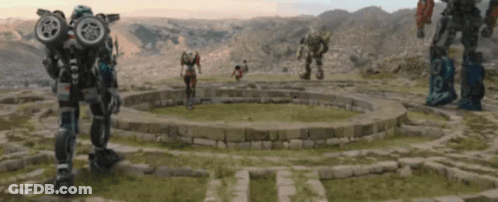 Group Of Robots Standing In A Circle In A Field GIF
