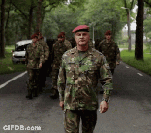 Group Of Soldiers Walking, One With Red Beret GIF