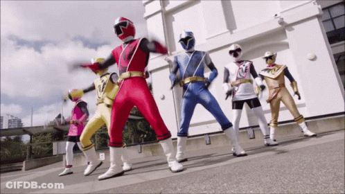 Group Of Superheroes Standing In Front Of Building GIF