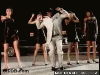 Group Of Women Dancing With Man In White Suit GIF