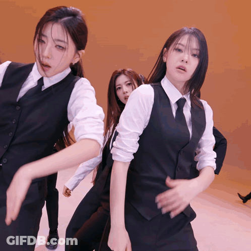 Group Of Women In Suits And Ties Dancing On Stage GIF