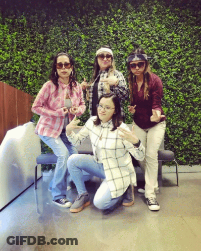 Group Of Women Posing In Front Of Hedge Wall GIF