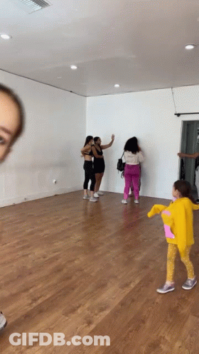 Group Of Women With Little Girl In Yellow Hoodie In Dance Studio GIF