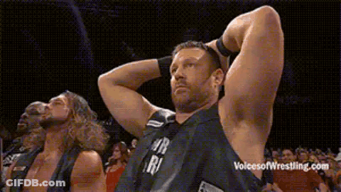 Group Of Wrestlers Standing With Hands Behind Head GIF