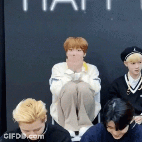 Group Of Young Men One Sitting Cross-Legged On Floor GIF