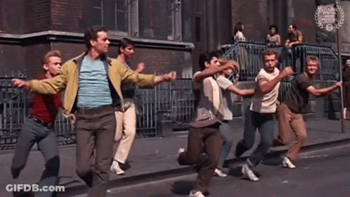 Group Of Young Men Running Down Street Holding Hands GIF