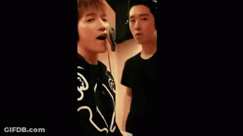 Group Of Young Men Singing Into Microphones GIF