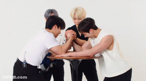 Group Of Young Men Standing Around Table One Pointing GIF