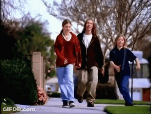 Group Of Young People Walking On Neighborhood Sidewalk GIF