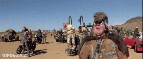 Group On Dirt Road, One Wearing Fur Coat GIF