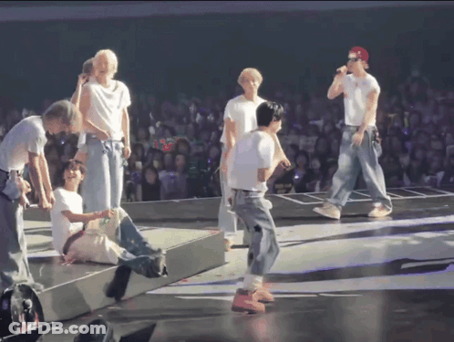 Group On Stage With Red Cap GIF