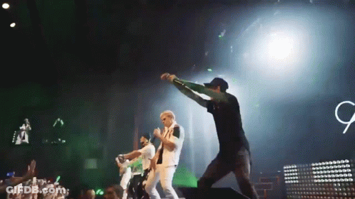 Group On Stage With Sign Saying G GIF
