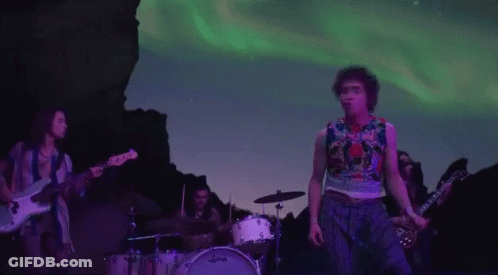 Group Playing Instruments On Stage In Front Of Mountain GIF