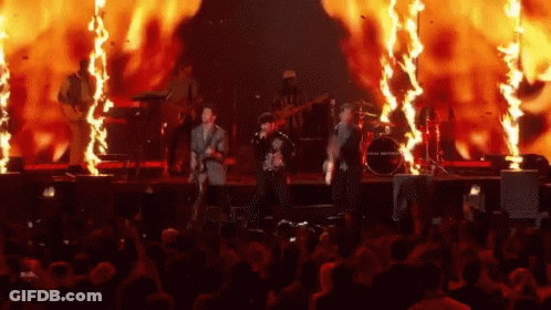 Group Playing Instruments On Stage With Fire GIF