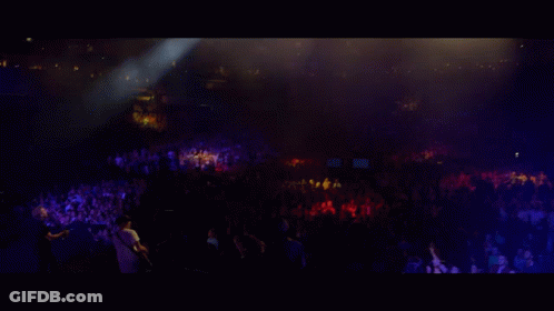 Group Playing Instruments On Stage With Large Screen Behind GIF
