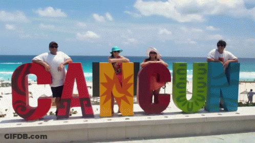 Group Posing In Front Of Cancun Sign GIF
