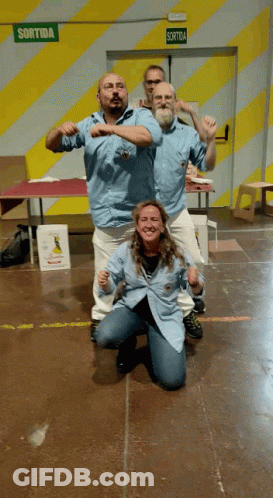 Group Posing In Front Of Green Sortida Exit Sign GIF