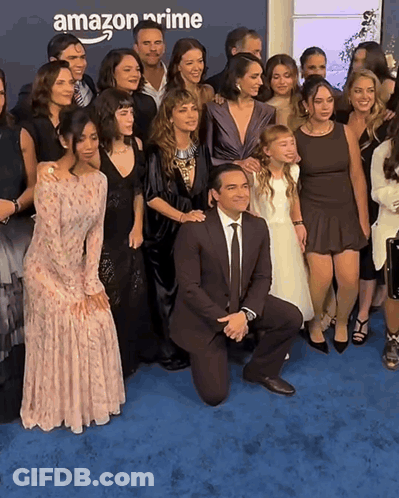 Group Posing On Blue Carpet With Amazon Prime Background GIF