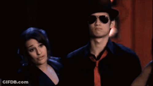 Group Posing On Stage With Red Curtain GIF