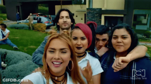 Group Posing With Nuestra Tele Logo GIF