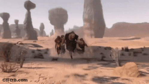 Group Running Through Desert With Rocks GIF