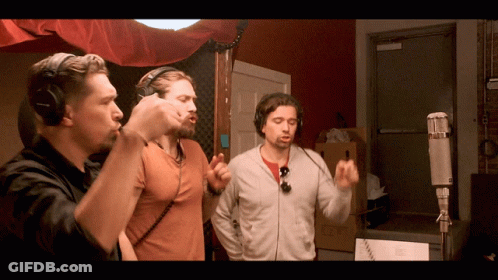 Group Sitting Around Table With Man Standing GIF