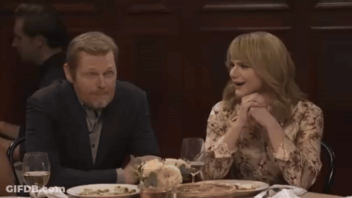 Group Sitting Around Table With Wine And Plates GIF