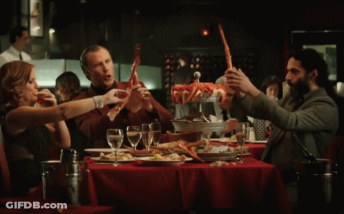 Group Sitting At Table Holding Crab Legs GIF