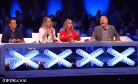 Group Sitting At Table With Large X GIF