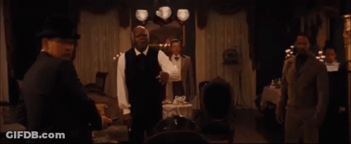 Group Sitting At Table With Man In Suit And Woman In White Dress GIF