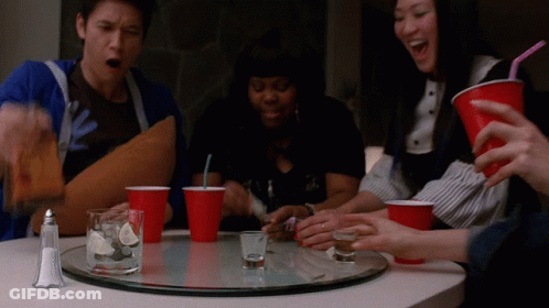 Group Sitting At Table With Shot Glasses And Red Cups GIF
