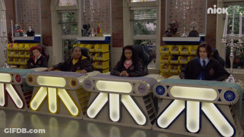 Group Sitting At Table With Sign Saying Nick GIF