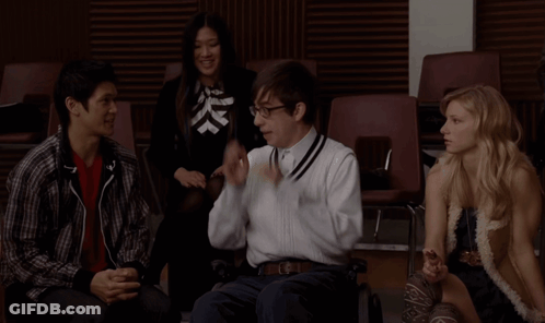 Group Sitting In Chairs One Talking On Phone GIF