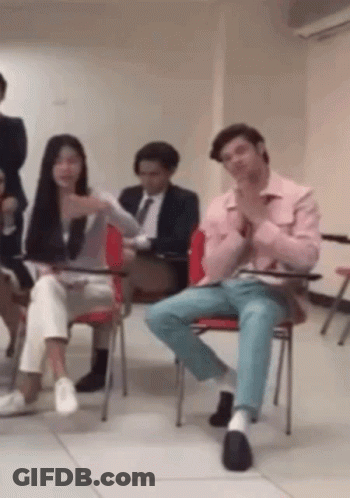 Group Sitting In Chairs With Man In Pink Shirt GIF