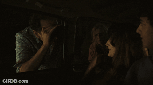 Group Sitting In Dark Room One Covering Face GIF