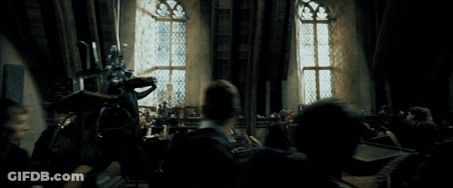 Group Sitting In Dark Room With Standing Man GIF