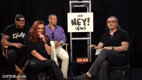 Group Sitting In Front Of Hey (Ew) Sign GIF