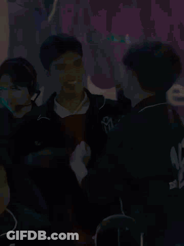 Group Sitting In Front Of Sign Saying We GIF