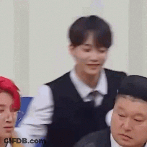 Group Sitting In Room One Wearing Vest GIF