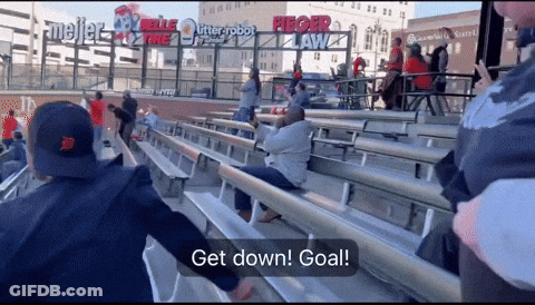 Group Sitting In Stadium Sign Says Get Down GIF
