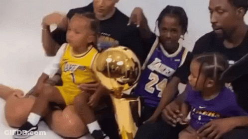 Group Sitting On Floor With Basketball Trophy GIF