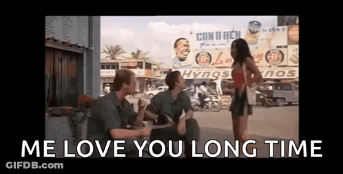 Group Sitting On Sidewalk Talking With Woman Standing GIF