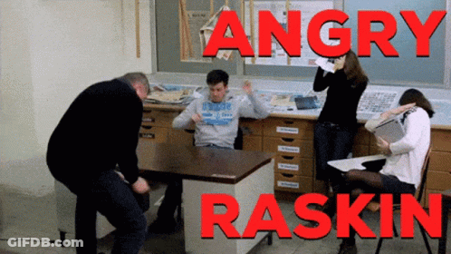 Group Standing Around Desk Angry Raskin GIF