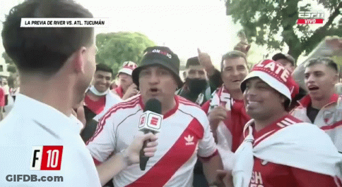 Group Standing Around Man Holding Microphone GIF
