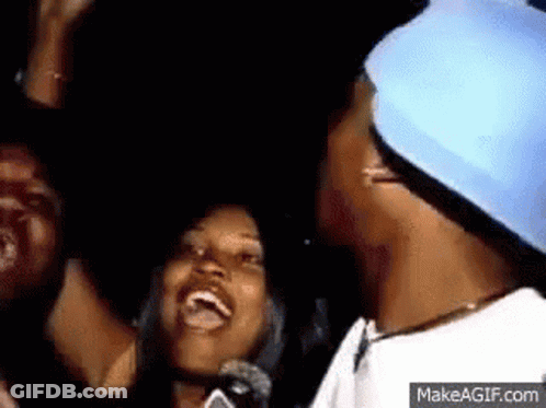 Group Standing Around Man In Blue Hat Smiling GIF