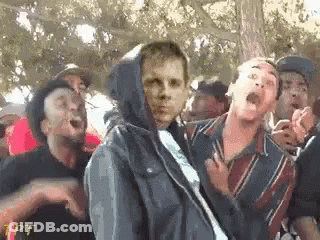Group Standing Around Man In Hoodie GIF